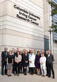 Several members of the Herbert Irving Comprehensive Cancer Center pose for a photo outside the Irving Cancer Research Center building.